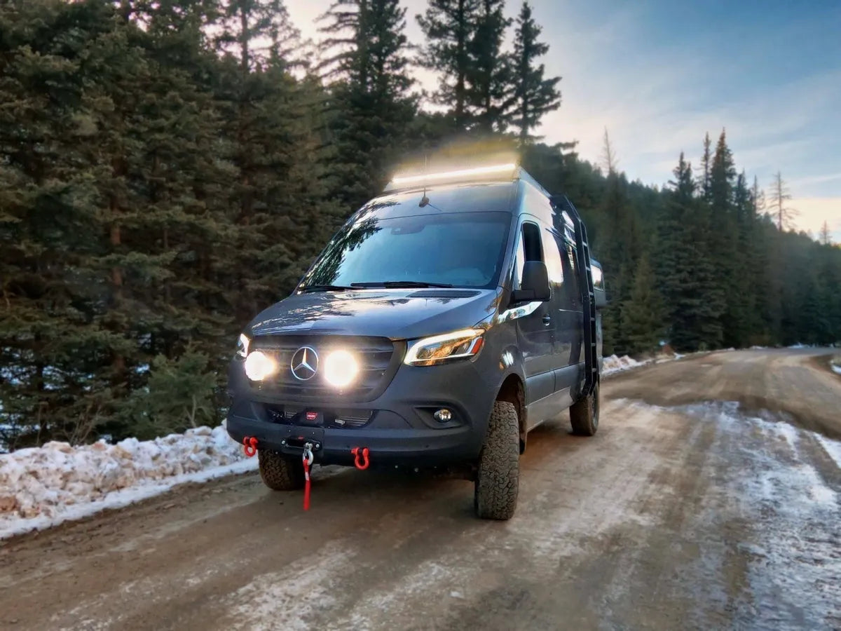 Gina Sprinter 4x4 van conversion front view on snowy mountain road with LED light bar