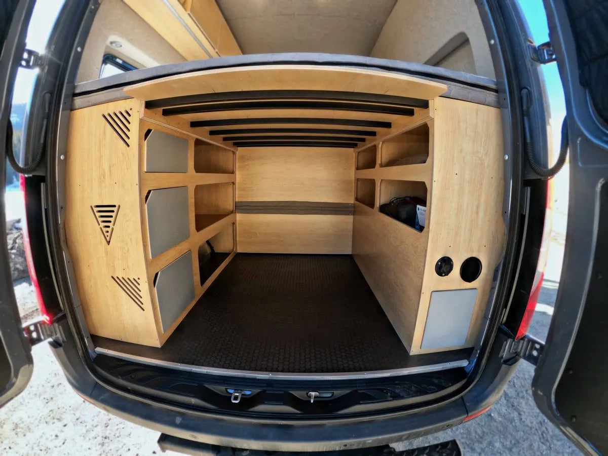 Rear garage storage with birch shelving and organized compartments in Gina van build