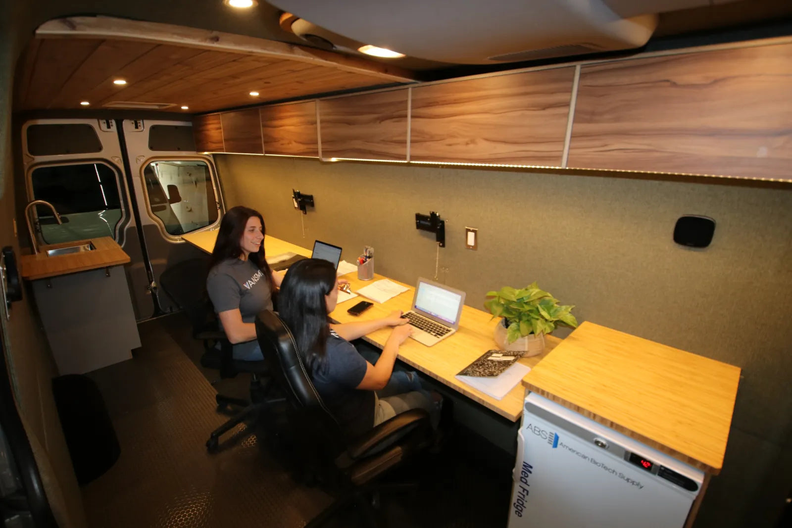 Hustle Sprinter van conversion interior mobile office with dual workstations and walnut desks by The Vansmith