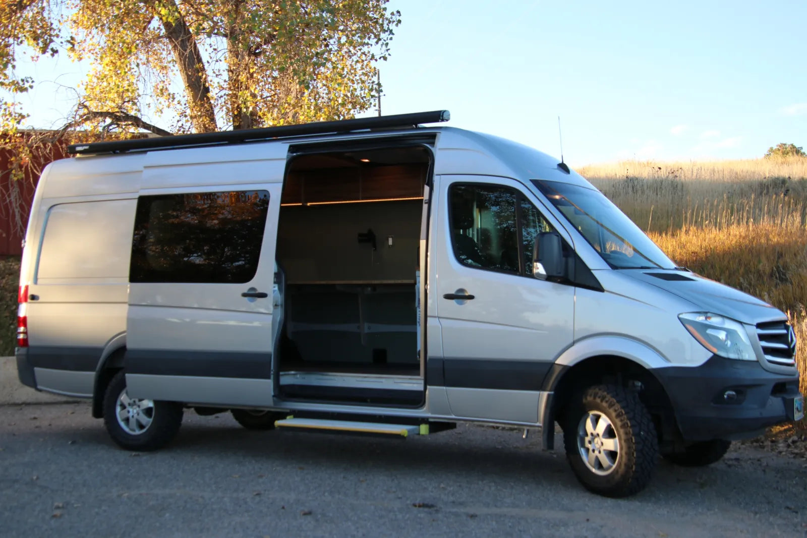 Hustle Sprinter 170 van conversion exterior side view with sliding door open and roof rack by The Vansmith