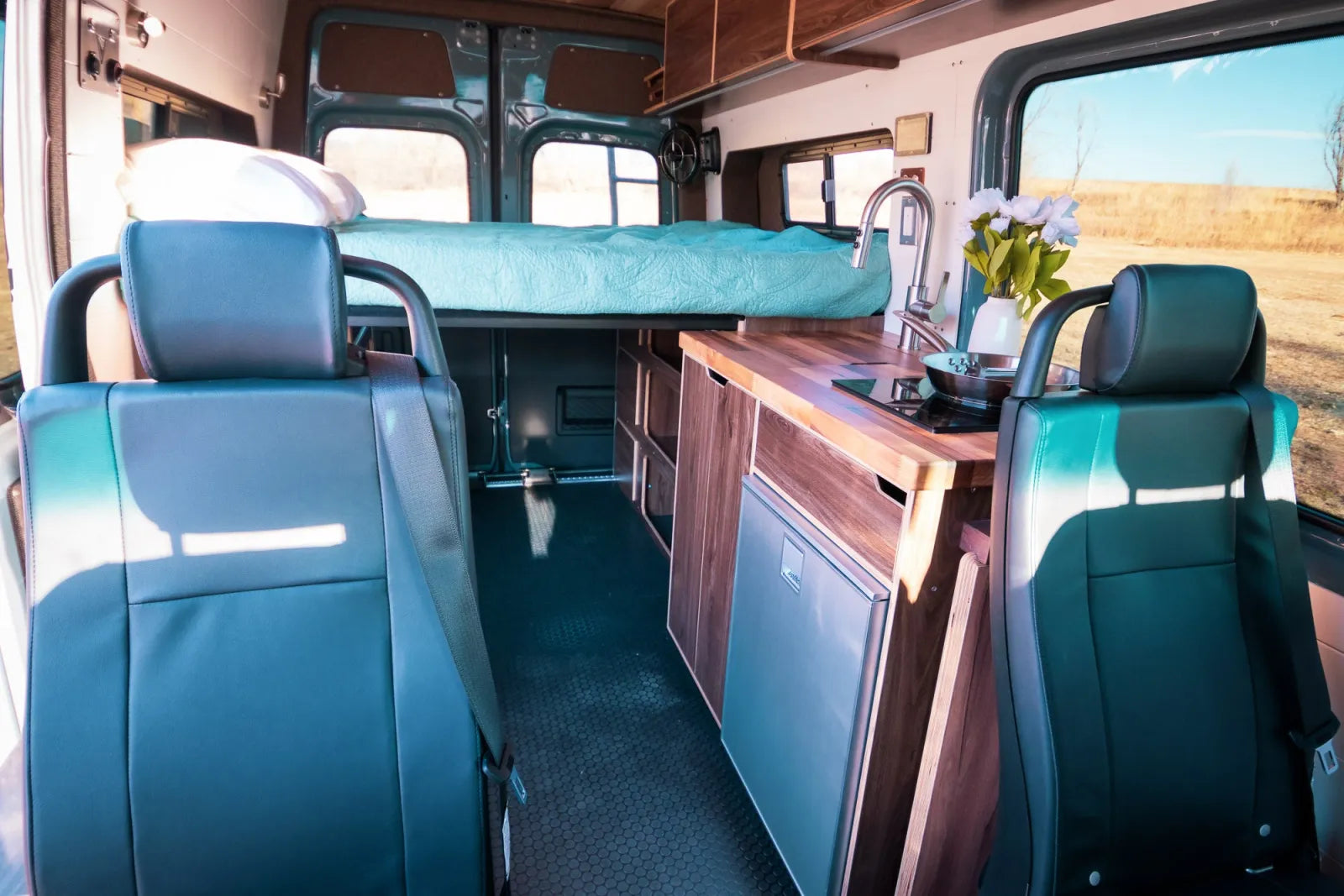 Jimmy Sprinter van side view with bed faucet and walnut cabinetry by The Vansmith