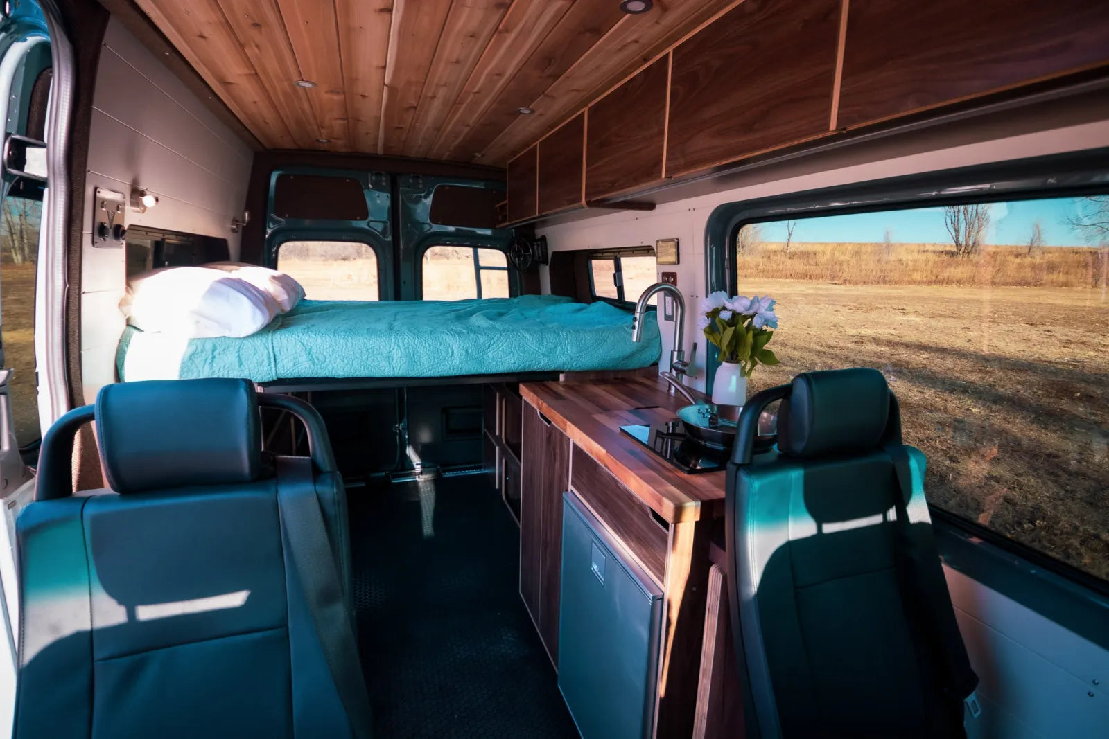 Jimmy van conversion full-length interior with cedar ceiling walnut kitchen and teal seats by The Vansmith