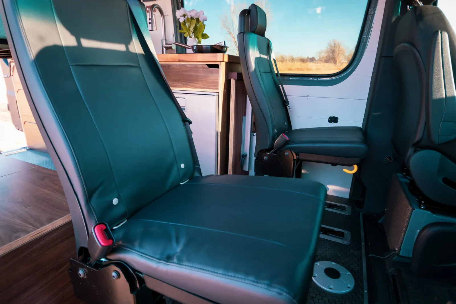 Jimmy Sprinter van teal leather swivel seats detail with seat belts by The Vansmith