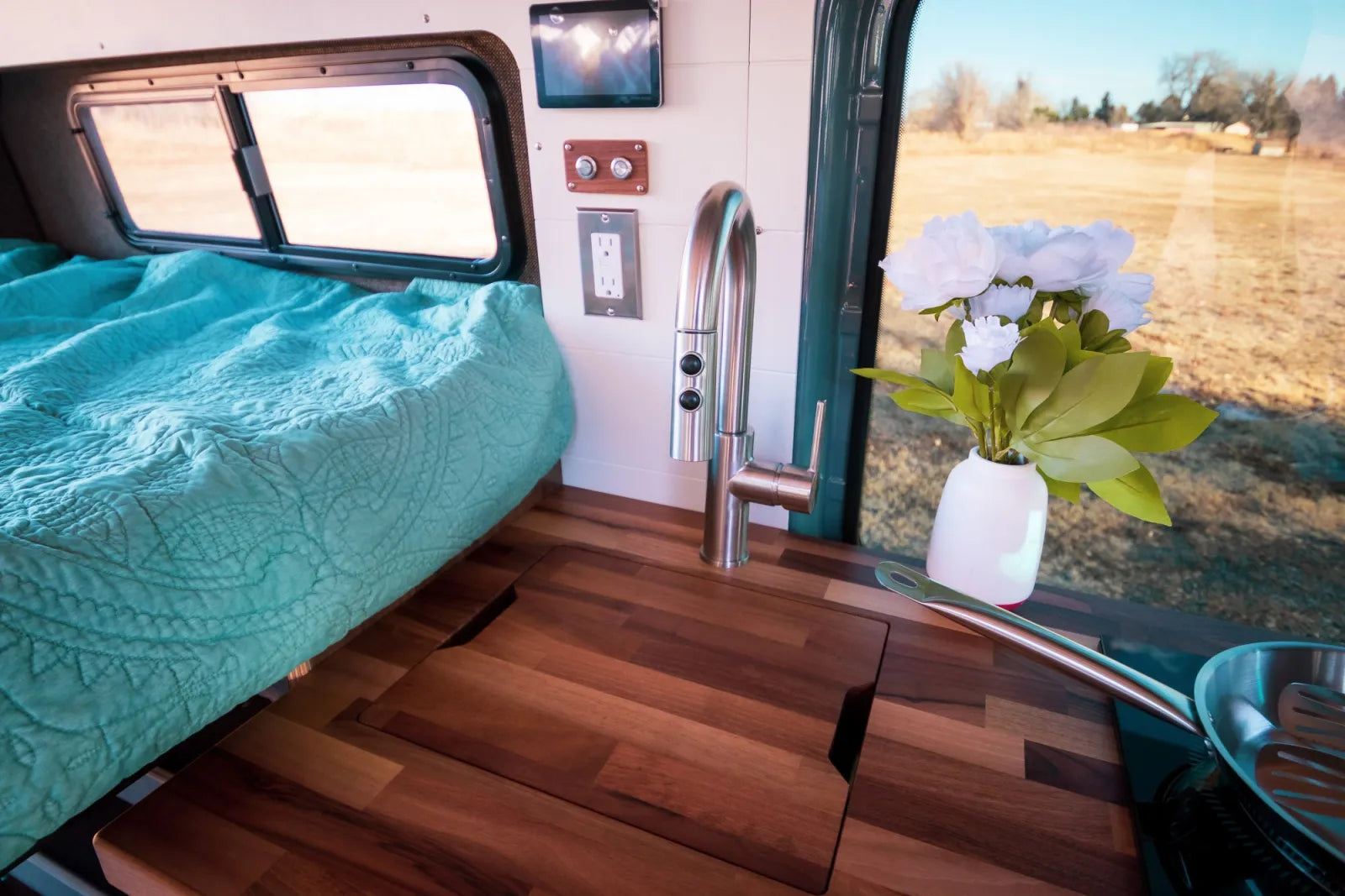 Jimmy van conversion walnut butcher block countertop with sink faucet and fresh flowers by The Vansmith