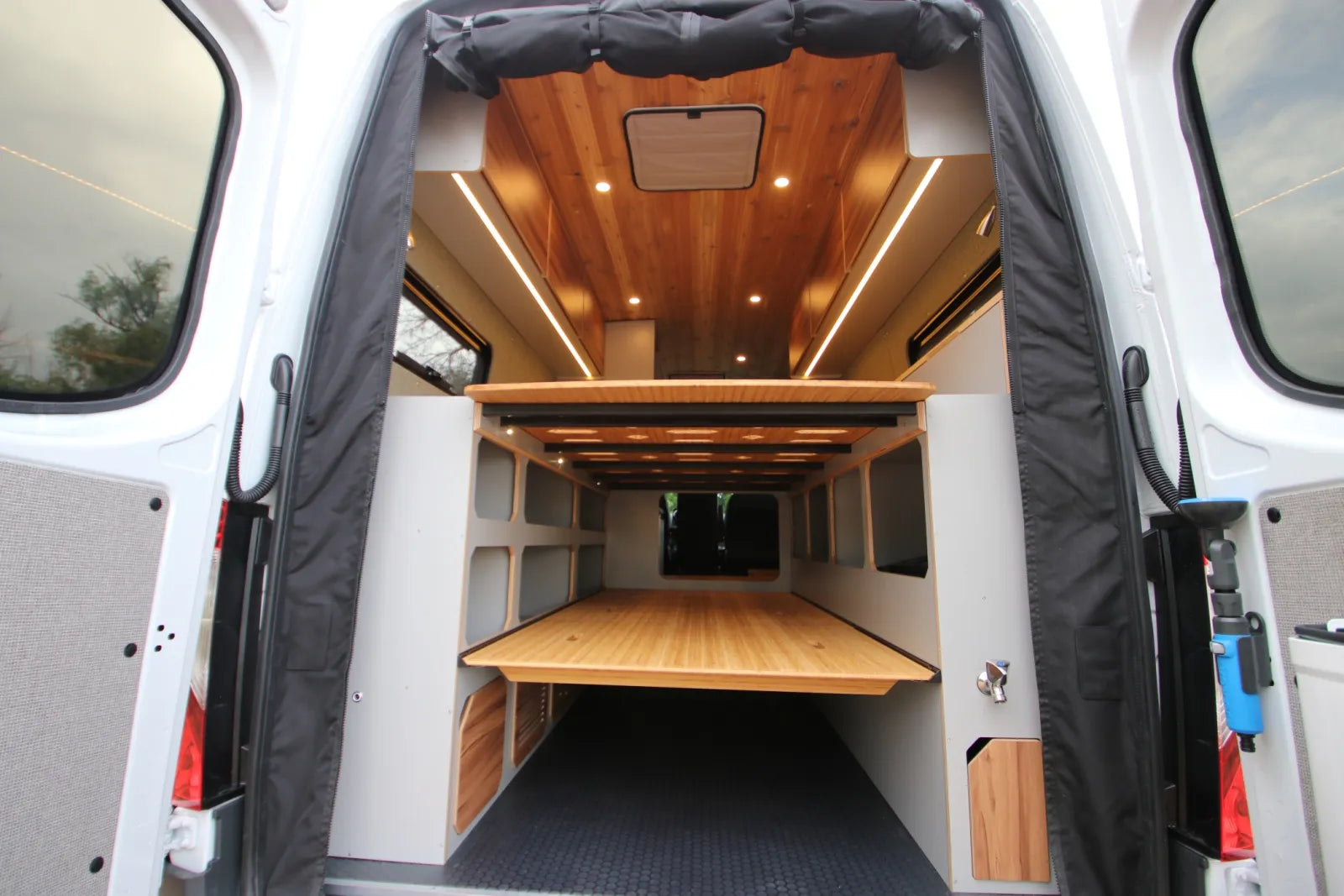 Maverick van conversion rear view with bed platform fold-out table and cedar ceiling by The Vansmith