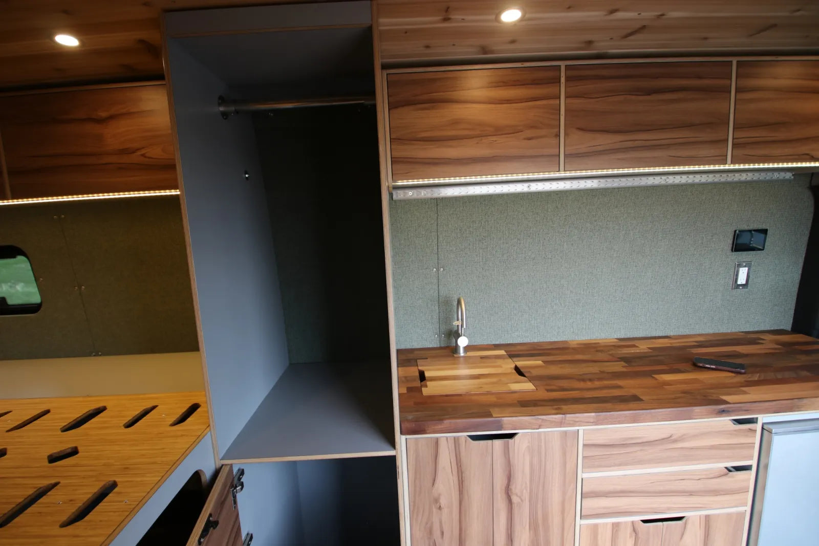 Maverick Sprinter van closet wardrobe next to walnut kitchen galley and countertop by The Vansmith