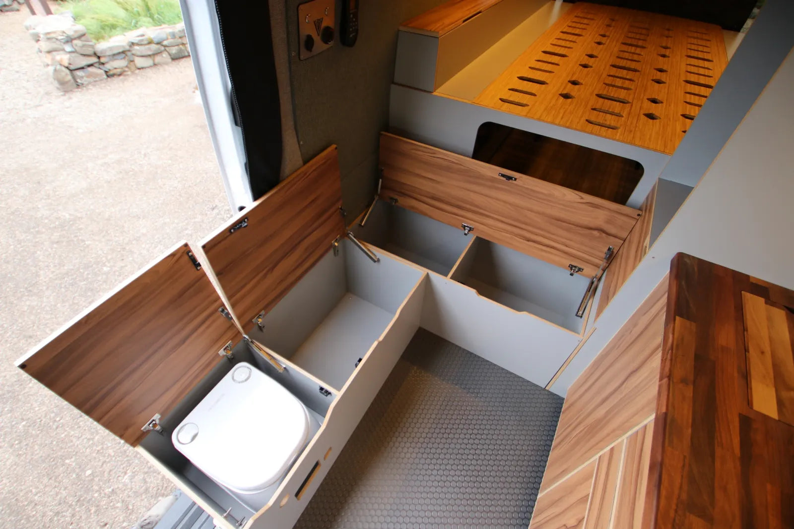 Maverick Sprinter van hidden toilet compartment with walnut lid storage access by The Vansmith
