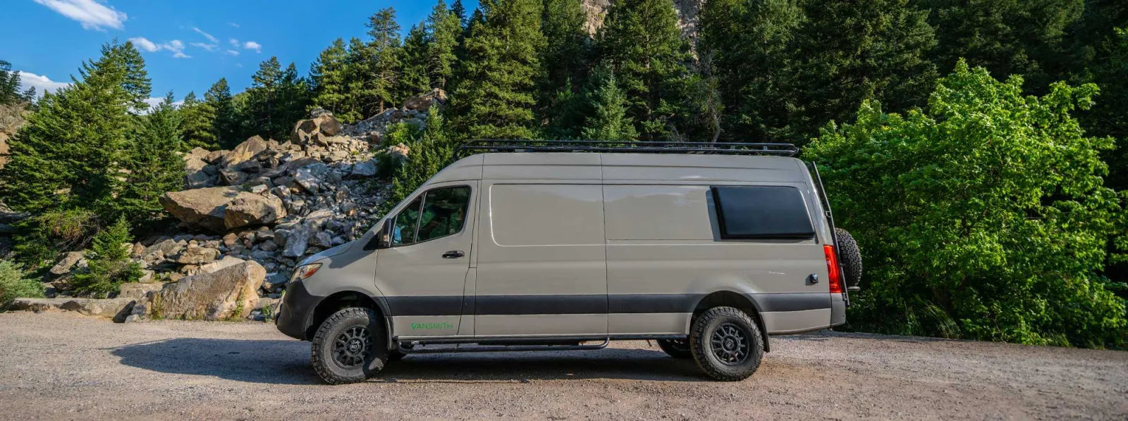 Outpost Sprinter 170 van conversion parked in a mountain forest with roof rack by The Vansmith