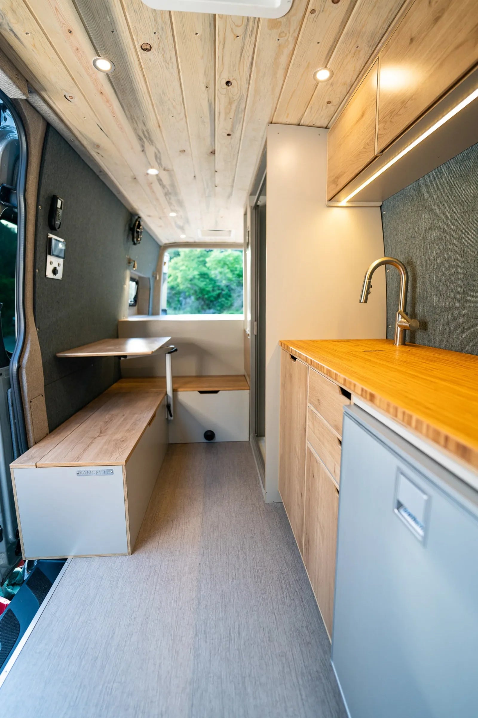 Outpost van full interior with kitchen galley, dinette, and cedar ceiling