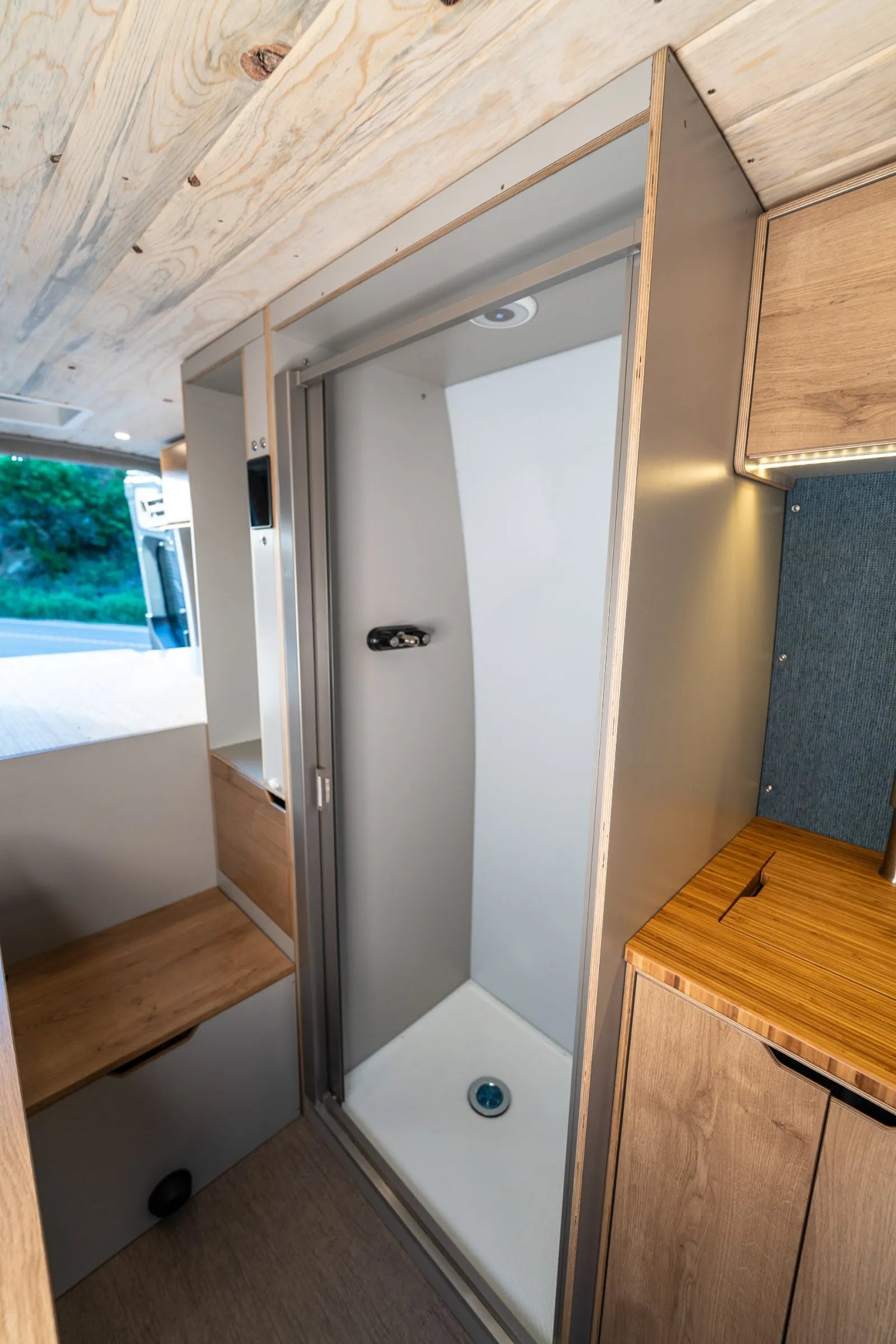 Outpost van enclosed shower stall with sliding door and overhead light