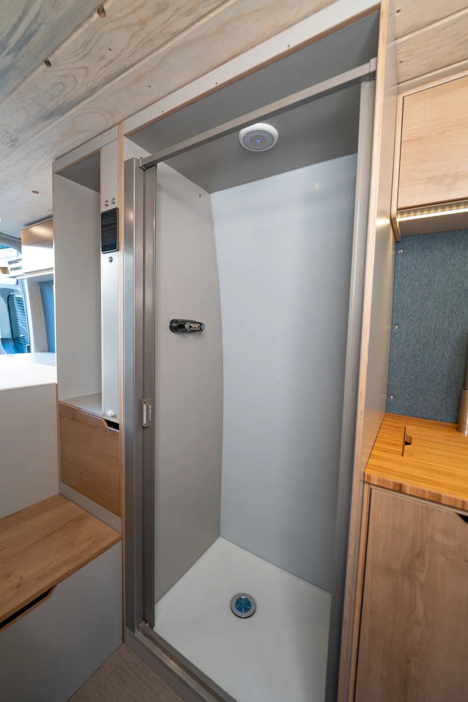 Enclosed shower with fiberglass pan in Outpost van conversion by The Vansmith