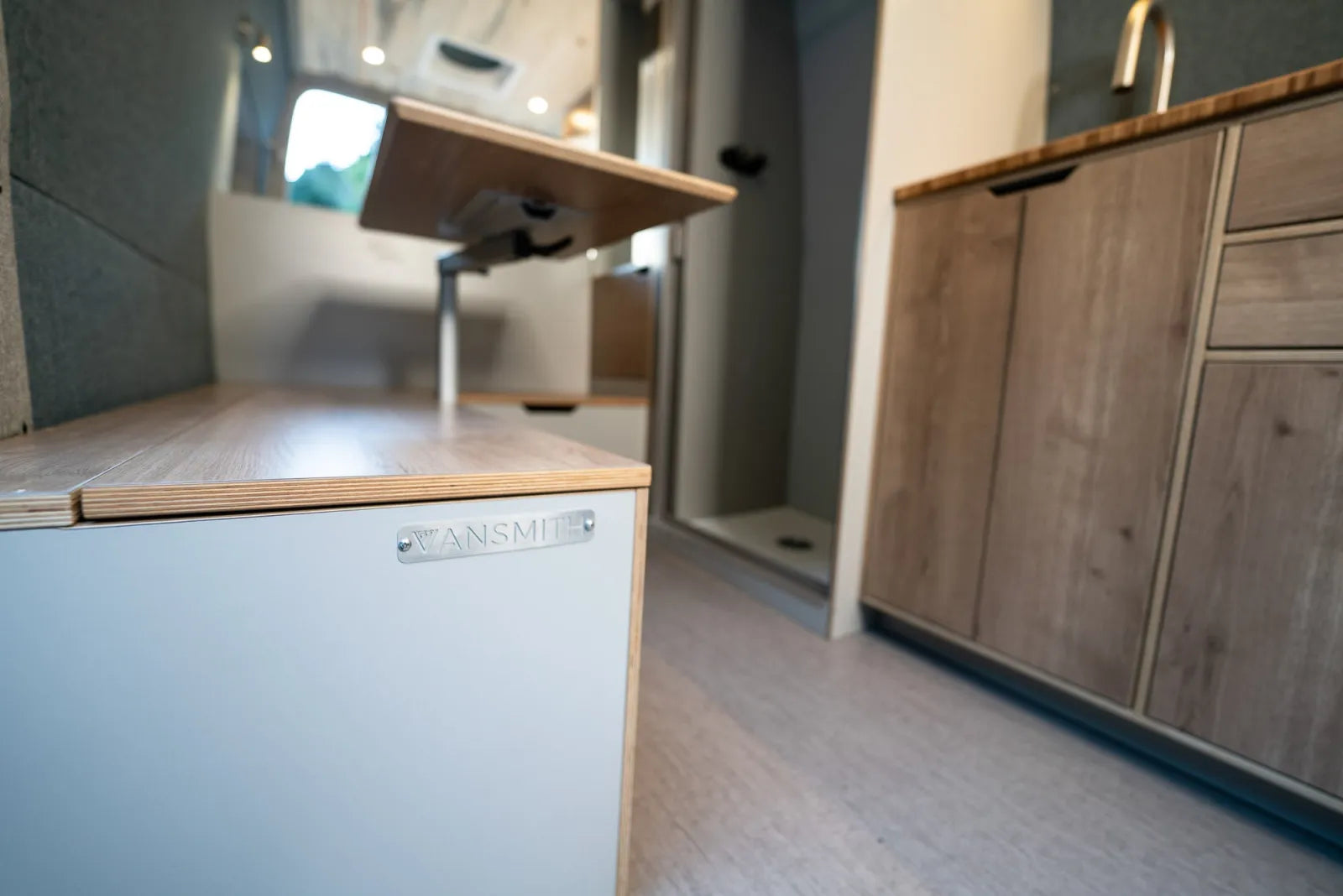 The Vansmith badge on cabinet with adjustable table in Outpost Sprinter van