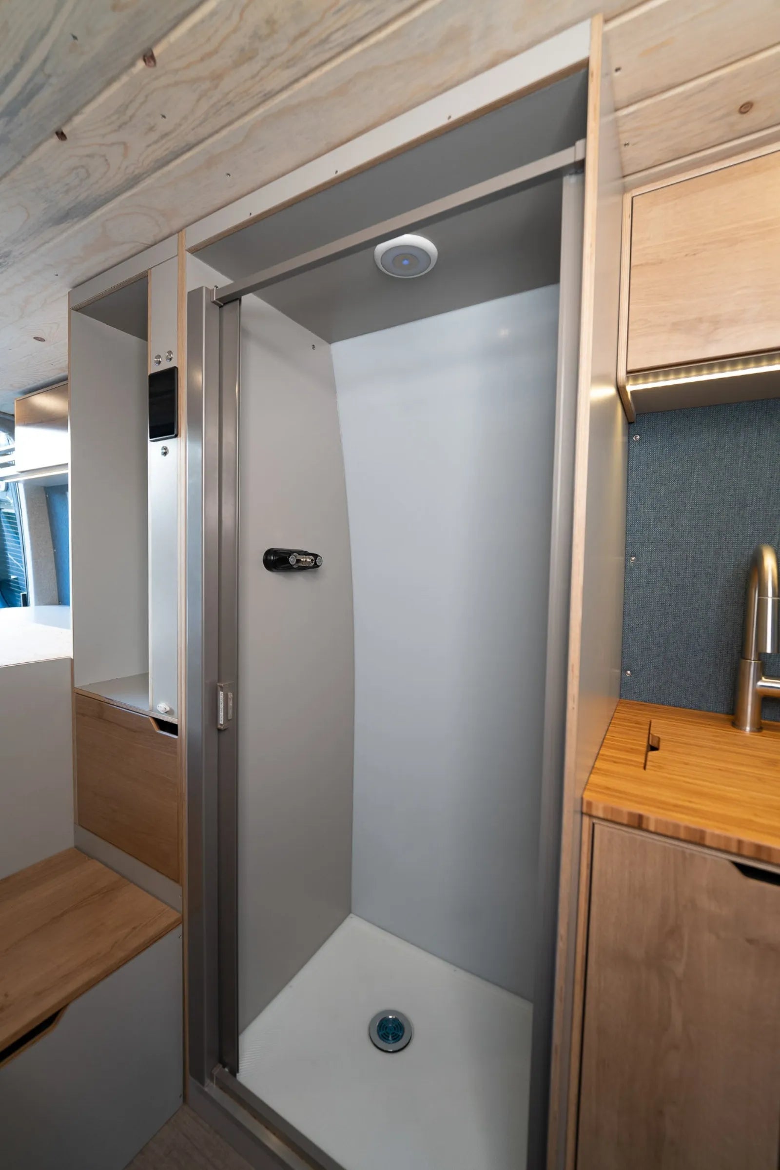 Outpost Sprinter enclosed shower open showing kitchen counter and cabinets