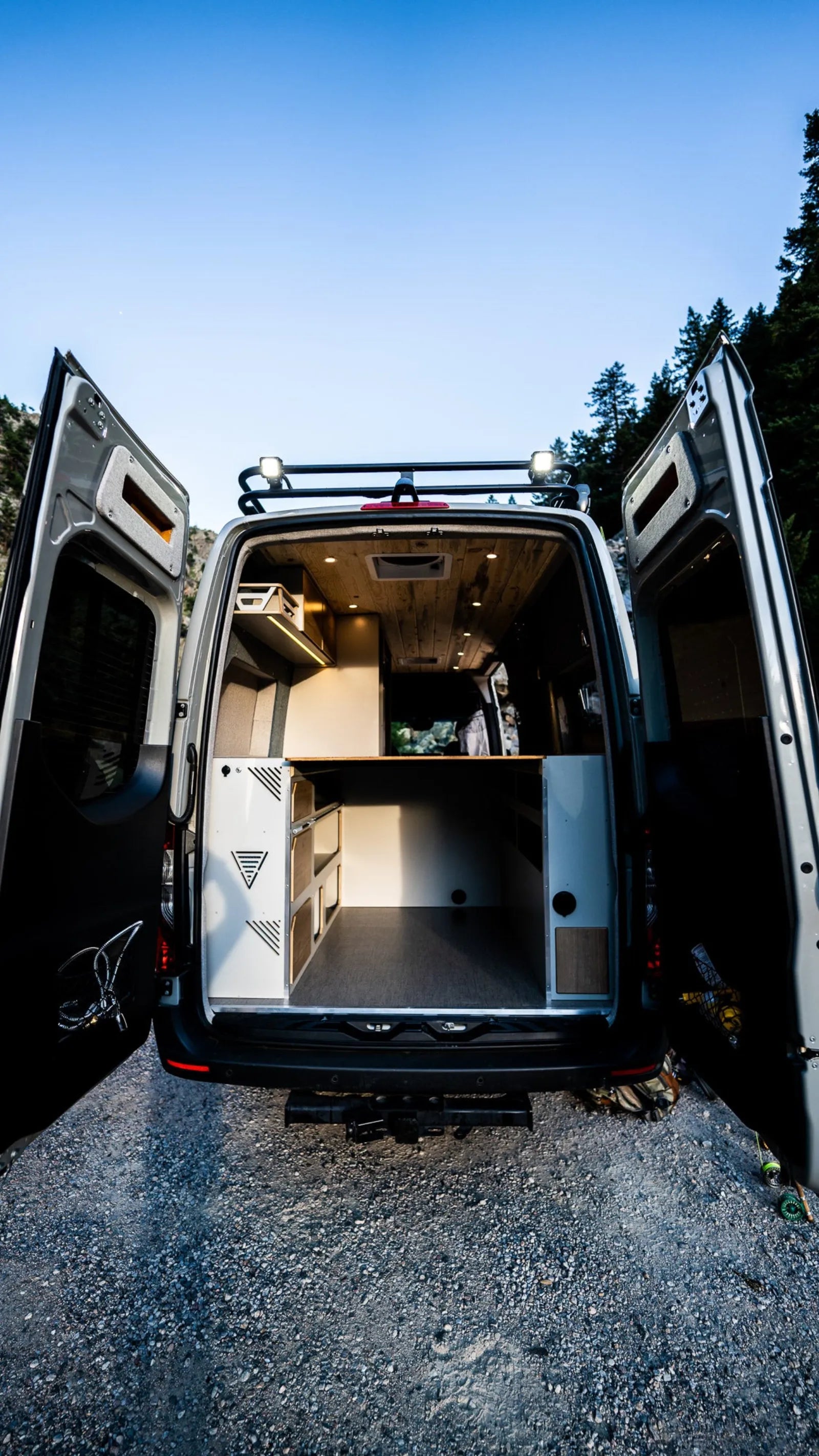 Outpost Sprinter rear view with doors open showing bed and storage cabinets