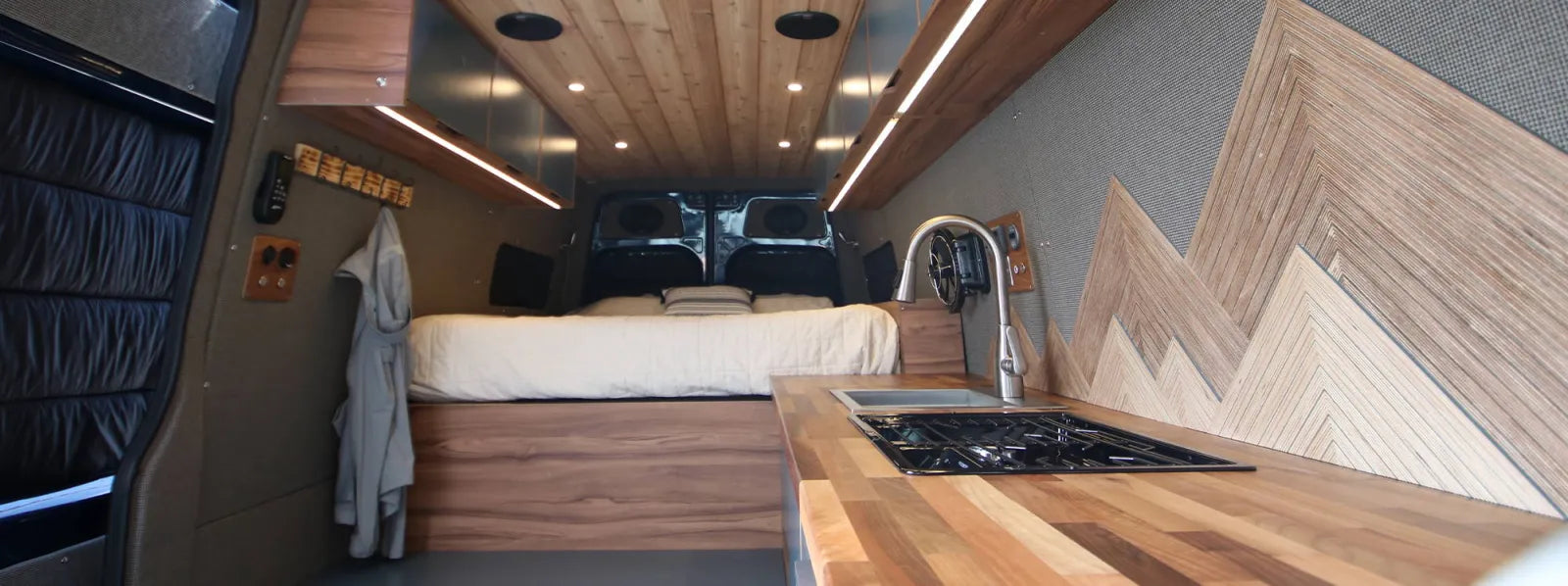 Rapp Sprinter 170 interior with cedar ceiling, mountain wall art, walnut kitchen, and cooktop by The Vansmith