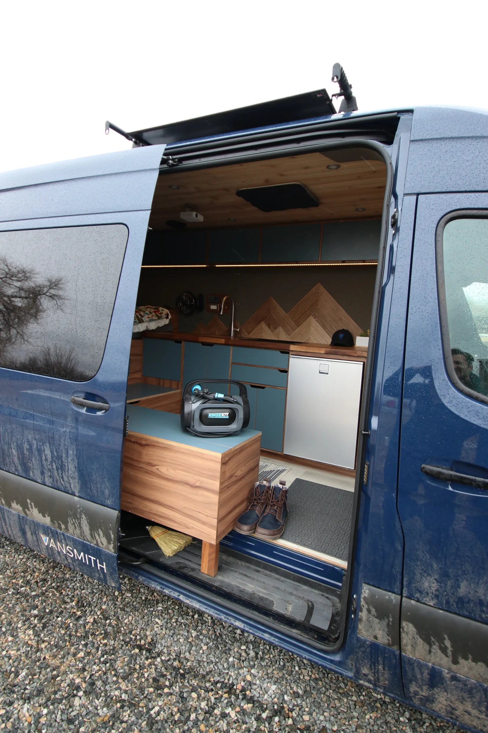 Rapp blue Sprinter exterior side door showing kitchen and bench seating