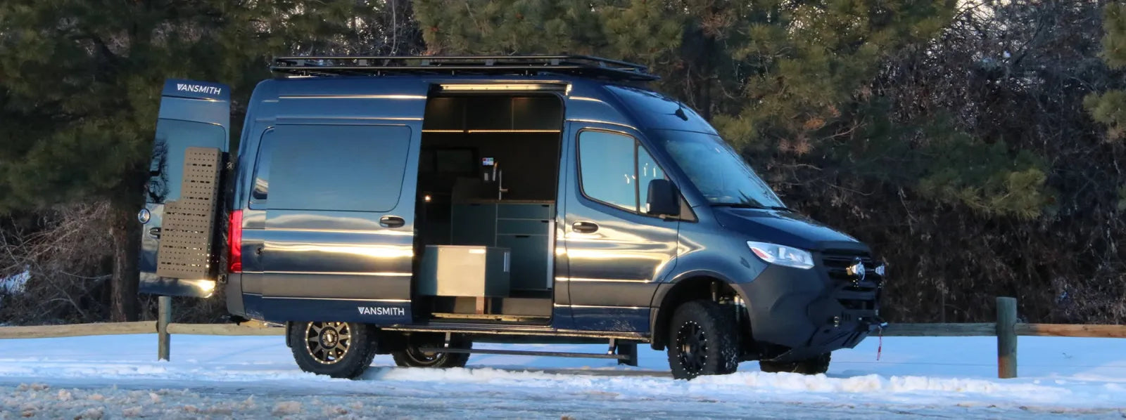 Spence Sprinter 144 dark gray van conversion with flares and rear shower in a snowy setting by The Vansmith