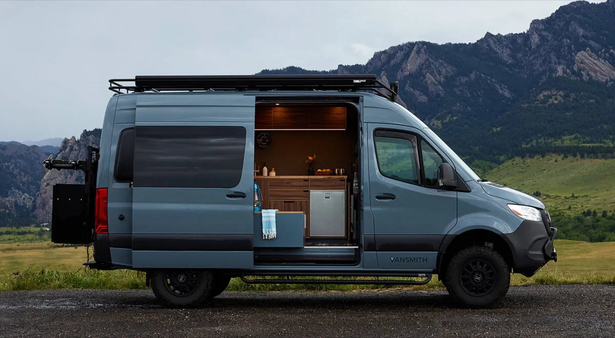 ThunderPig Sprinter 144 4x4 blue van conversion with open door showing kitchen near Boulder Flatirons by The Vansmith